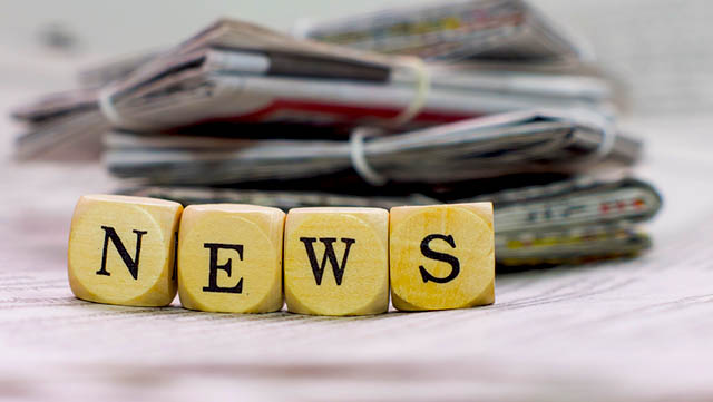 Blocks that spell out news sits in front of newspaper